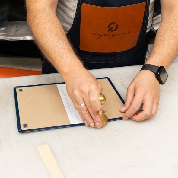 Craftsman hand-sewing a piece of leather in a workshop